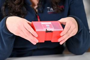 Hands holding red KitBox D with locking device