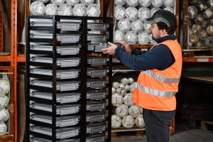 Man taking kitting case from kitting trolley
